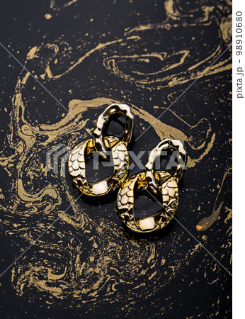 Golden chains earrings on black background. 98910680
