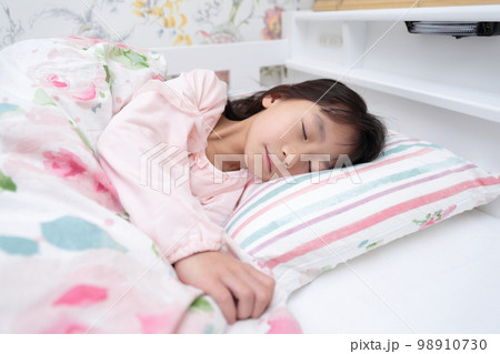 ベッドで眠る小学生の女の子 98910730