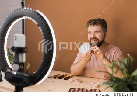 Portrait bearded man making vlog review cosmetics product and channel recording video make up tutorial making at home - Online influencer guy and social media market live steaming concept 98911341