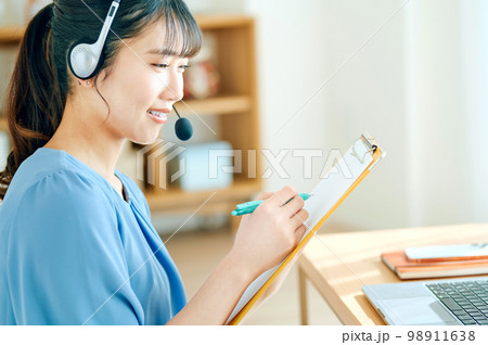自宅で働くテレワーク中の若い女性オペレーター 自宅で働くテレワーク中の若い女性オペレーター 98911638