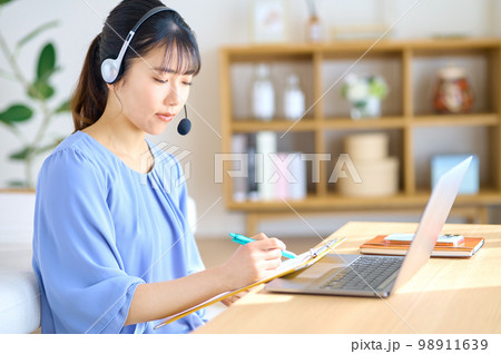 自宅で働くテレワーク中の若い女性オペレーター 自宅で働くテレワーク中の若い女性オペレーター 98911639