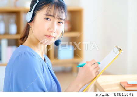 自宅で働くテレワーク中の若い女性オペレーター 98911642