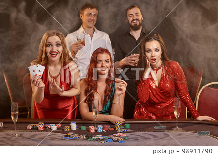 Group of a young wealthy friends are playing poker at a casino. Group of a young wealthy friends are playing poker at a casino. 98911790
