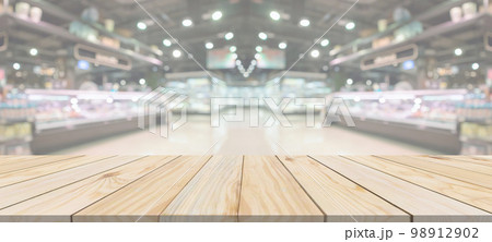 Wood table top with supermarket grocery store blurred defocused background with bokeh light for product display Wood table top with supermarket grocery store blurred defocused background with bokeh light for product display 98912902