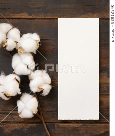 Blank card with cotton flowers top view on dark brown wood, wedding menu mockup Blank card with cotton flowers top view on dark brown wood, wedding menu mockup 98913540