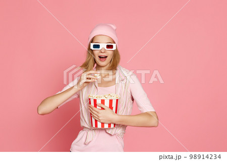 pretty blonde girl holding bucket of popcorn pretty blonde girl holding bucket of popcorn 98914234