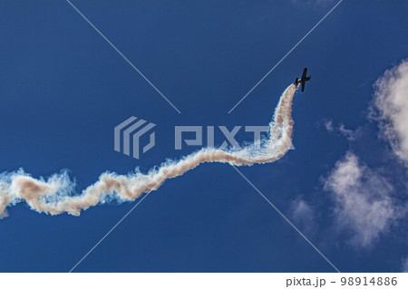 Sports plane performing an acrobatic stunt against a blue sky Sports plane performing an acrobatic stunt against a blue sky 98914886