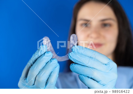 Doctor holding dental mouthguard, splint for the treatment of dysfunction of the temporomandibular joints, bruxism, malocclusion, to relax the muscles of the jaw. 98916422