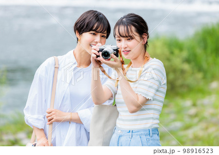 女子旅でカメラを持って観光する若い女性 98916523