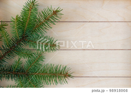Christmas tree branches on a wooden striped background, good for Christmas background 98918008