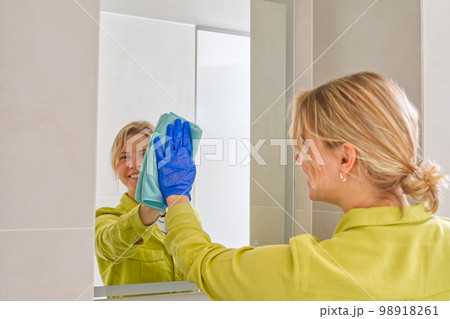 cleaning company. hotel maid microfiber cloth washing cleaning a mirror. household service concept cleaning company. hotel maid microfiber cloth washing cleaning a mirror. household service concept 98918261