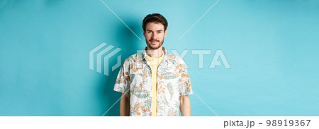 Happy handsome guy smiling, wearing hawaiian shirt on vacation. Concept of summer holiday 98919367