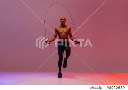 Man skipping with jump rope on studio background. Strength and motivation. Best cardio workout 98920689