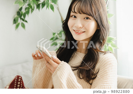 ソファーでくつろぐ女性　スマートフォン 98922880
