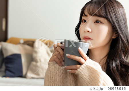 コーヒー・紅茶を飲む若い女性 98923016