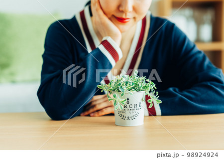 観葉植物を育てる若い女性 98924924