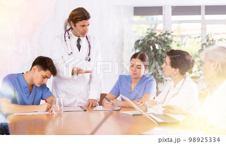 Medical director holds a meeting with colleagues in the office of clinic 98925334