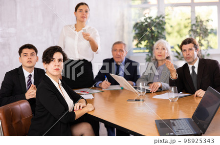 Young Hispanic businesswoman listening to presentation of partners 98925343