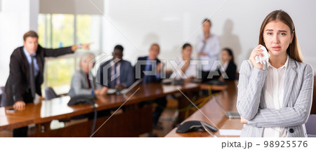 Portrait of young woman manager crying in meeting room Portrait of young woman manager crying in meeting room 98925576