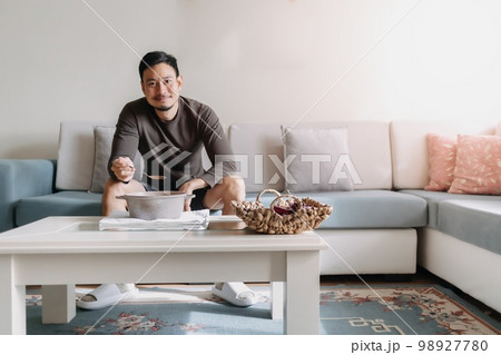 Lonely man having a meal alone in his home. 98927780