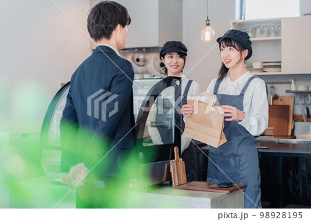 洋菓子店でお菓子を買うビジネスマン 洋菓子店でお菓子を買うビジネスマン 98928195