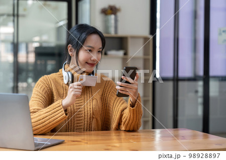 Asian woman holding credit card for online shopping and payment makes a purchase on the Internet, Online payment, Business financial and technology Asian woman holding credit card for online shopping and payment makes a purchase on the Internet, Online payment, Business financial and technology 98928897