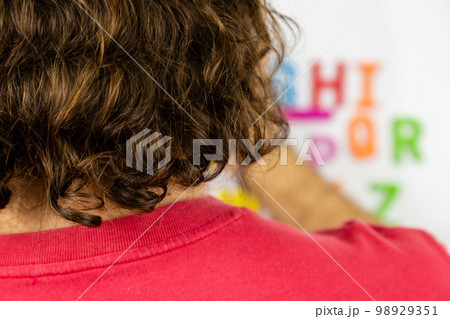 Over the shoulder shot of person looking at alphabet magnets Over the shoulder shot of person looking at alphabet magnets 98929351