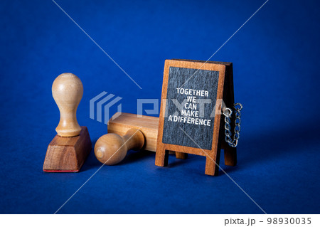 Together We Can Make A Difference. Miniature chalkboard on a blue background Together We Can Make A Difference. Miniature chalkboard on a blue background 98930035