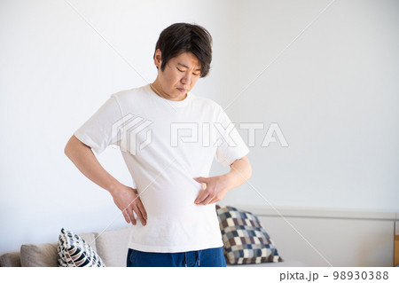 皮下脂肪をつまむ若い男性 98930388