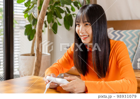 テレビゲームを楽しむ若い女性　お家時間 98931079