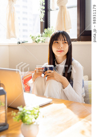 ノートパソコンで動画を観る若い女性 98931179