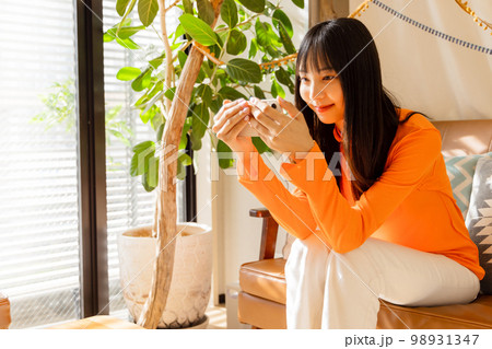 スマートフォンで動画を楽しむ女性 98931347