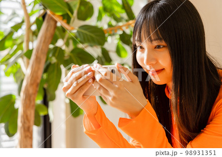 スマートフォンで動画を楽しむ女性 98931351
