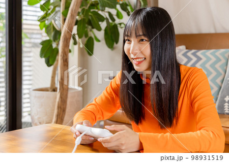 テレビゲームを楽しむ若い女性　お家時間 98931519