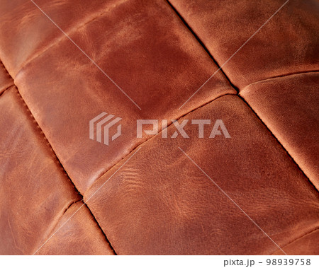 Background of stitched square patches of copper-coloured leather 98939758