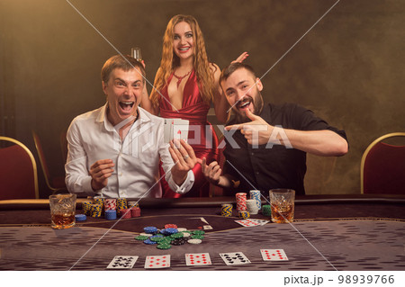 Group of a young wealthy friends are playing poker at a casino. 98939766
