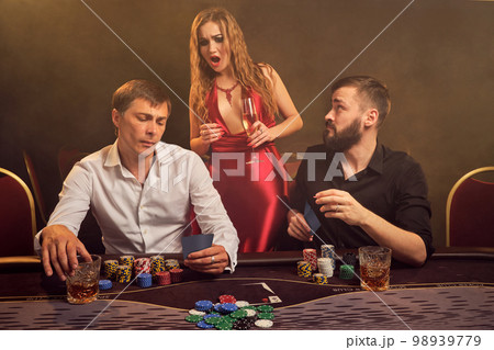 Group of a young wealthy friends are playing poker at a casino. Group of a young wealthy friends are playing poker at a casino. 98939779
