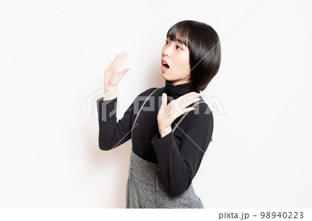 驚いている黒い服を着た若い女性 98940223