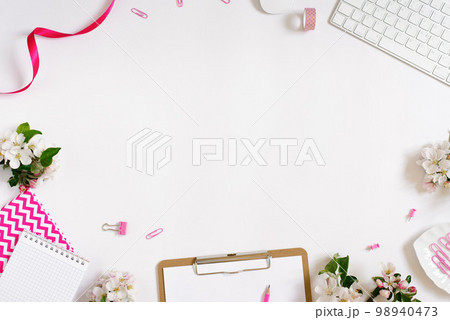 On a white flat lay background with apple flowers keyboard and stationery clips, a female floral desktop. The concept of a stylish spring morning. top view and copy space 98940473