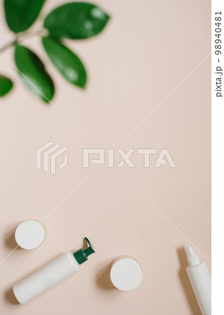 Organic herbal cosmetics in bottles and cans on a beige background with tropical leaves Organic herbal cosmetics in bottles and cans on a beige background with tropical leaves 98940481