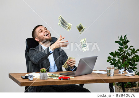 young bearded businessman working on laptop and throwing money young bearded businessman working on laptop and throwing money 98940676