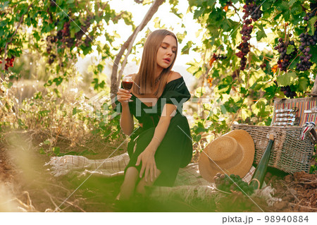 Young blonde woman sitting on a picnic in a vineyard 98940884