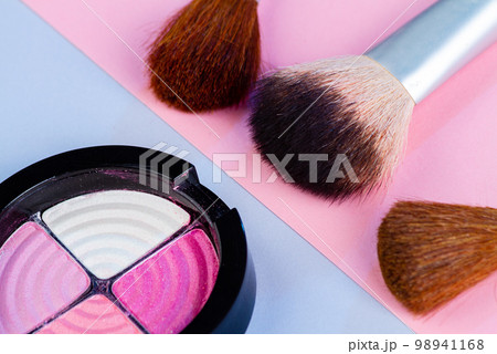 Close up of round eyeshadow palette with brushes. Cosmetic makeup accessories. 98941168
