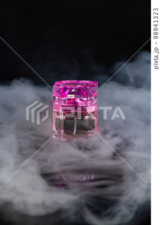 Pink bottle of womans perfume with vapor. Fragrance perfume bottle mockup on black background. Pink bottle of womans perfume with vapor. Fragrance perfume bottle mockup on black background. 98941323