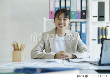 Yong Asian confident businesswoman is smiling and looking at camera 98941681