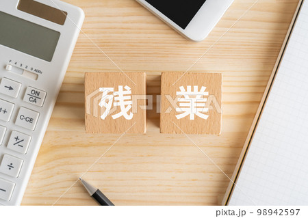 残業と書かれたブロック、電卓、スマホ、ノート 残業と書かれたブロック、電卓、スマホ、ノート 98942597