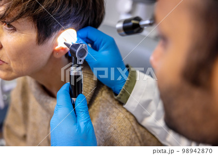 Senior woman having hearing checkup at ent doctor 98942870