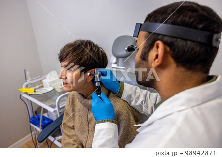 Senior woman having hearing checkup at ent doctor 98942871