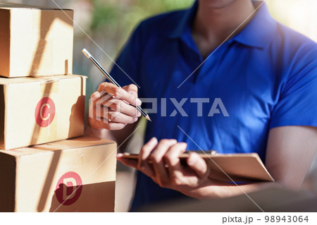 Asian courier with parcel and delivery logistic concept. Delivery man with checking list on clipboard 98943064