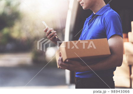 Asian courier with parcel and delivery logistic concept. Delivery man using delivery app by smartphone 98943066